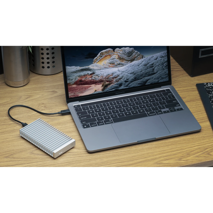 OWC Express 1M2 external SSD drive on a desk attached to macbook pro laptop